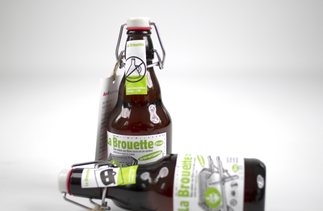 Une bière des Franches-Montagnes et une couchée auxquelles sont accrochées les étiquettes ArcExpress