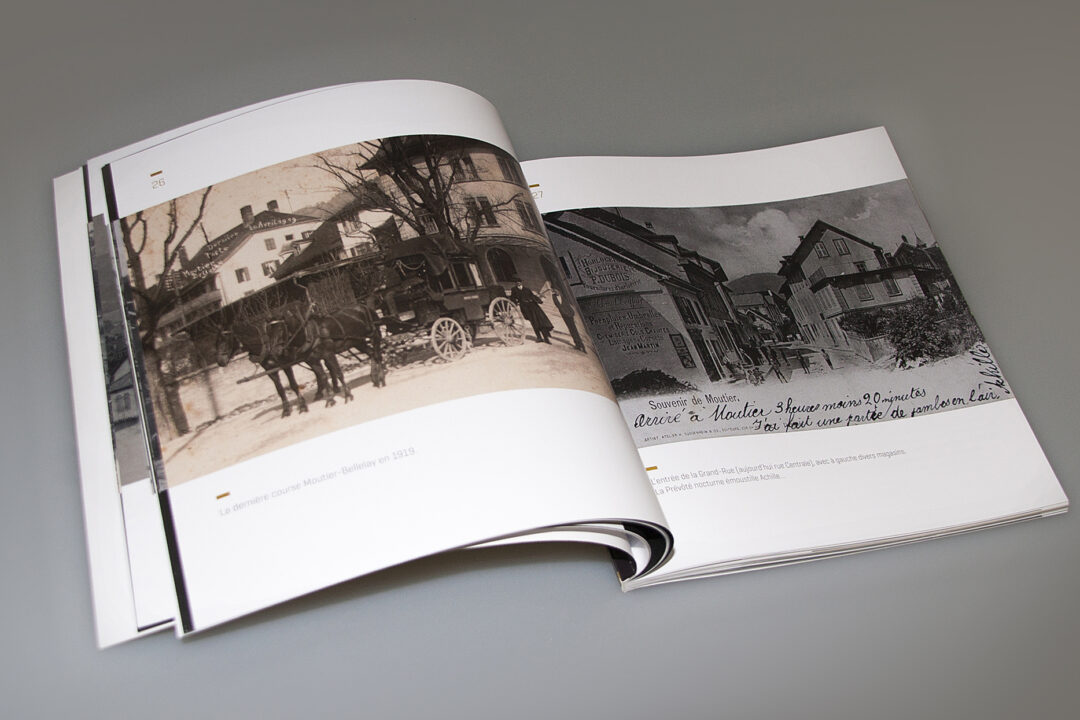 Livre des cartes postales de Moutier ouvert où l'on peut voir des vieilles images de la ville de Moutier.