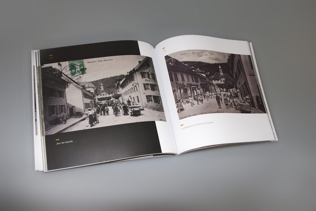 Livre des cartes postales de Moutier ouvert où l'on peut voir des vieilles images de la ville de Moutier.