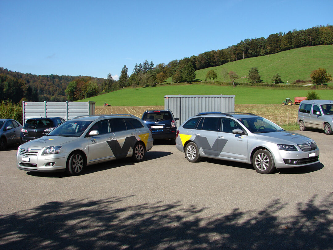 Deux voitures dans un parking, sur lesquelles se trouvent le logo Wibemo.