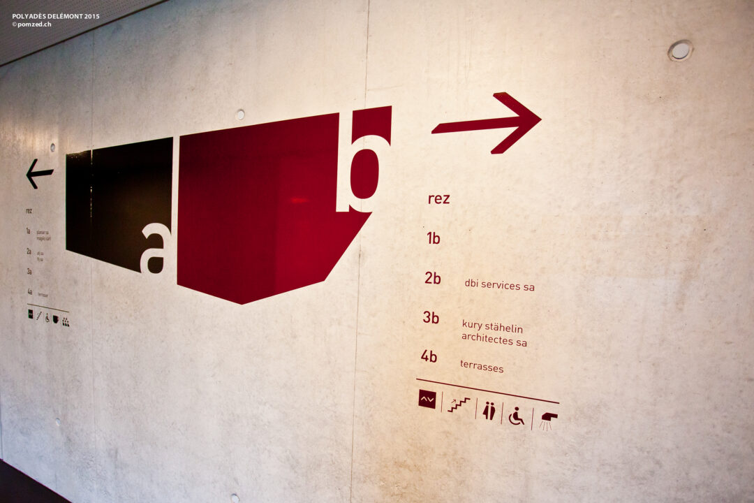 Signalétique sur un mur dans un couloir de Polyades.