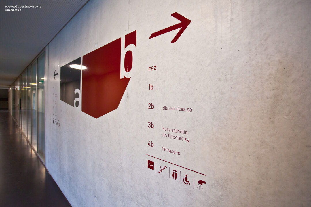 Signalétique sur un mur dans un couloir de Polyades.