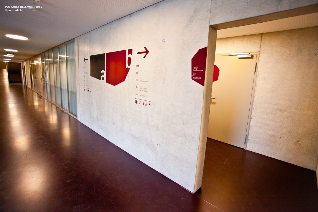 Signalétique sur un mur dans un couloir de Polyades.