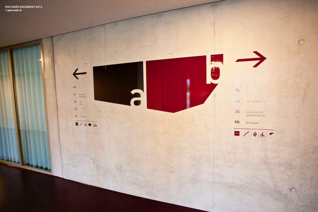 Signalétique sur un mur dans un couloir de Polyades.