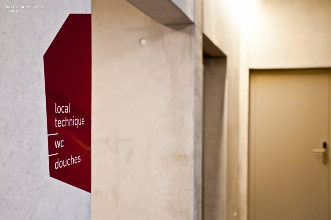 Signalétique sur un mur dans un couloir de Polyades.