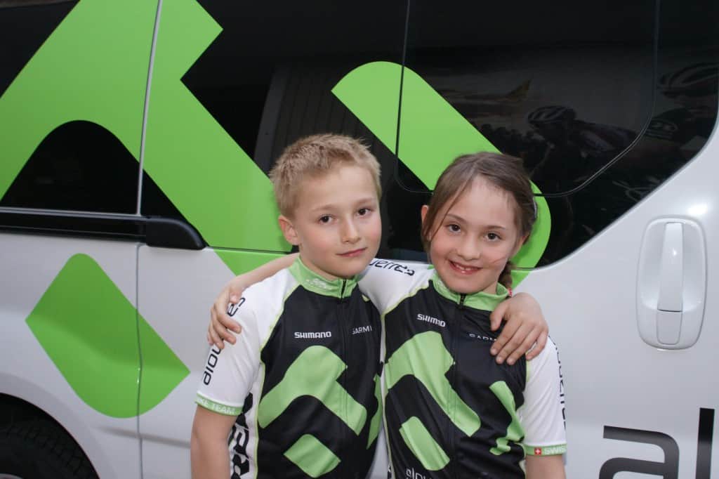 Deux enfants se tenant par les épaules portant des habits de sport Alouettes Cycles.