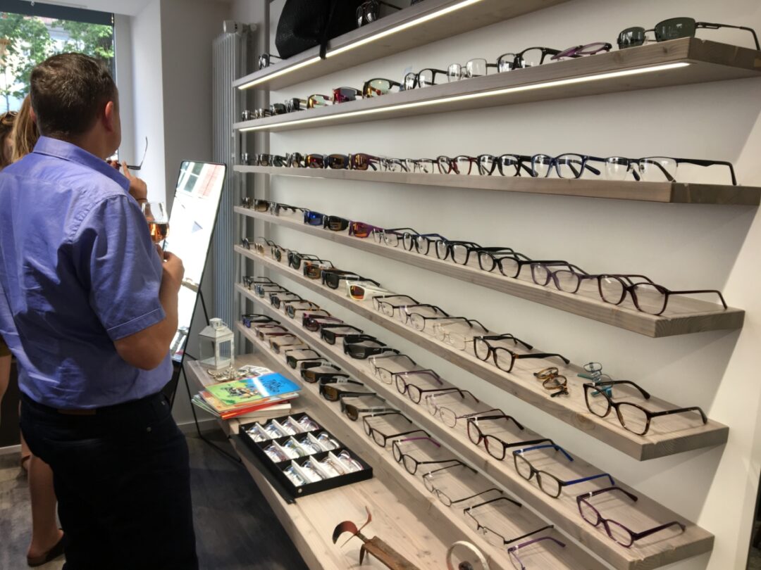 Deux personnes en train d'essayer des lunettes chez Houlmann optique.