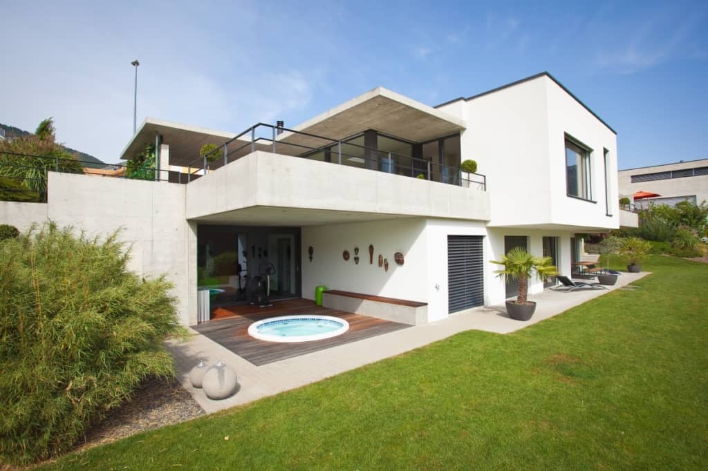 Maison vu de l'extérieur avec un jacousie sur la terrasse.